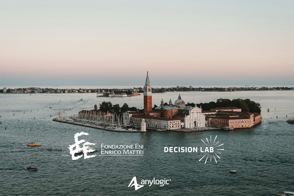A scenic photograph of the island of San Giorgio Maggiore in the Venice lagoon at dusk. Overlaid are the logos of the project collaborators Fondazione Eni Enrico Mattei and Decision Lab, alongside the AnyLogic logo, signifying their work on climate risk in the region.